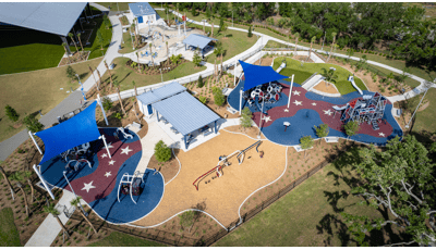 Elevated view of two separate play areas with multiple structures and large blue shades over head.